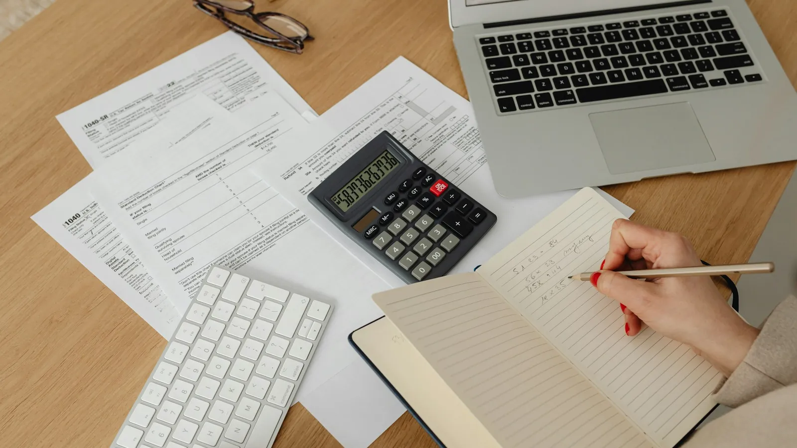 Startup founder reviewing eligible SR&ED expenditures with tax forms and a calculator.