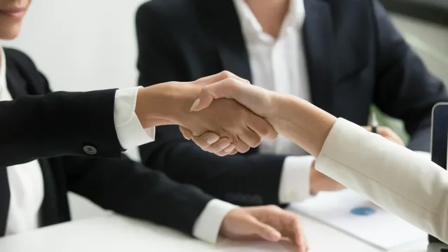 Poignée de main lors d'une rencontre visant un partenariat technologique international.