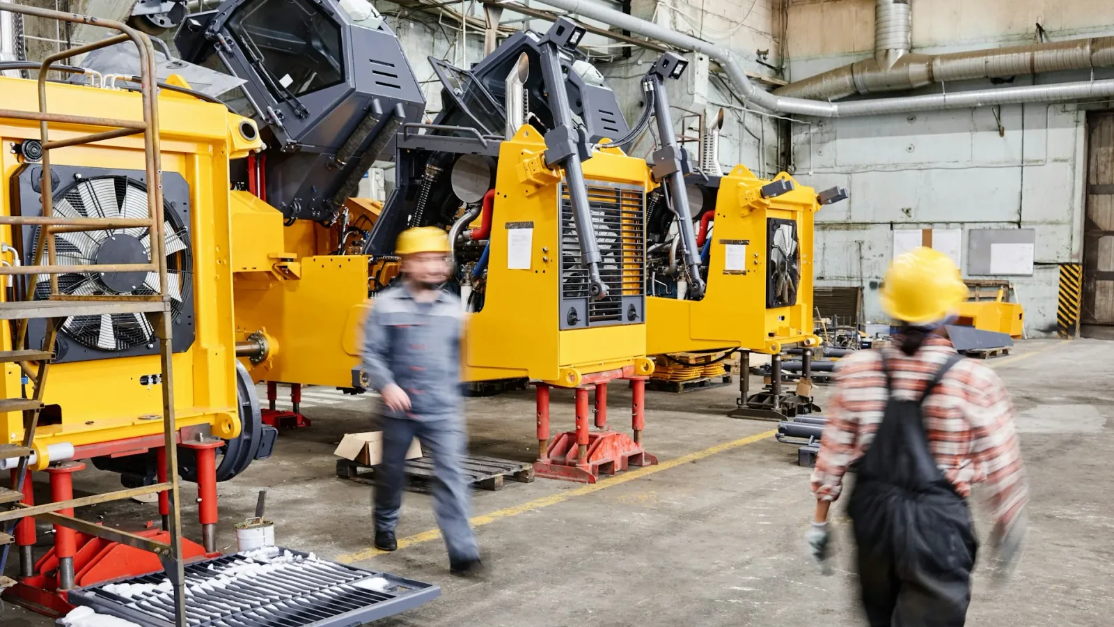 Techniciens travaillant sur de la machinerie industrielle dans une usine.