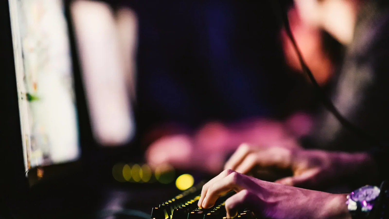 Professional working at a keyboard in a digital production studio.