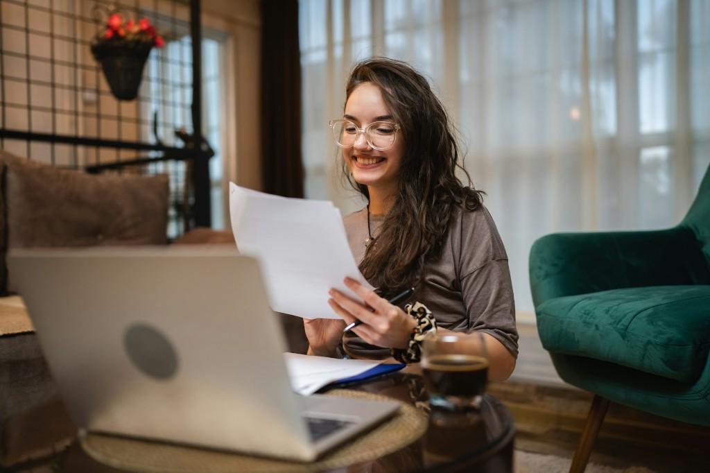 Professionnelle examinant des documents financiers avec ordinateur — démarche pour le crédit d’impôt RS&DE (recherche et développement) au Québec et au Canada.